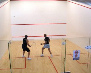 Olahraga squash di lapangan indoor tertutup dengan tempo permainan cepat