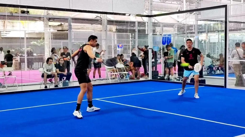 Komunitas padel lokal bermain bersama di lapangan kaca sebagai bagian dari networking olahraga