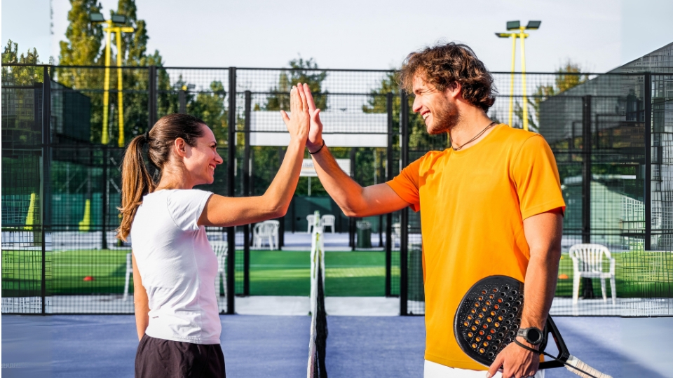 Pemain padel bermain ganda di lapangan kaca sebagai olahraga sosial untuk networking bisnis