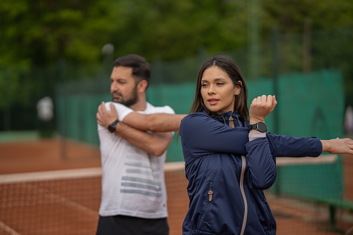 Pemain padel melakukan peregangan sebelum pertandingan turnamen