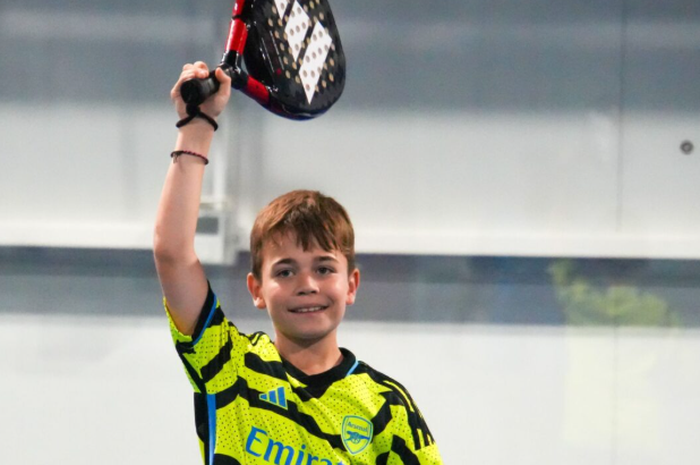 Anak-anak belajar padel bersama pelatih di lapangan, menggunakan raket junior dan bola low compression