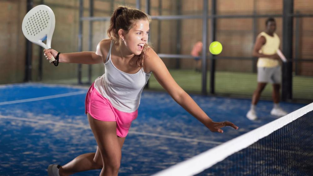 pemain padel membuat konten media sosial di lapangan padel untuk membagikan pengalaman bermain
