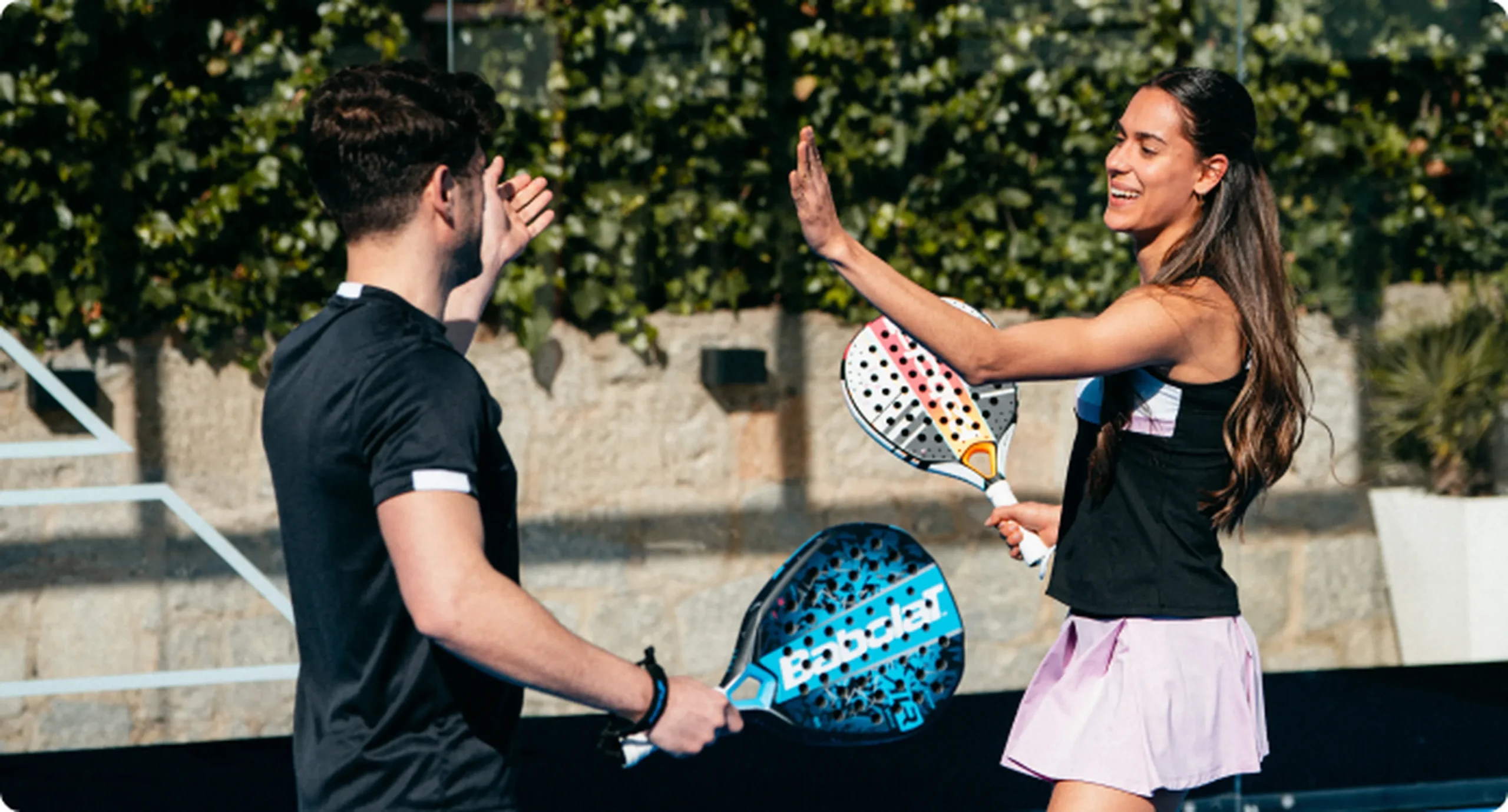 pemain padel melakukan high five setelah memenangkan poin