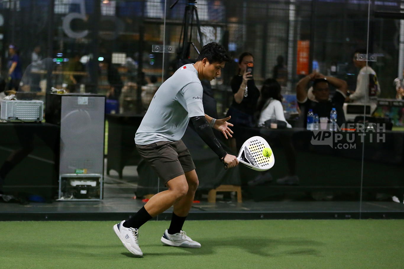 pemain padel menonton rekaman pertandingan untuk mengevaluasi permainan