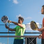 Pemain padel membawa raket dan tas olahraga di lapangan